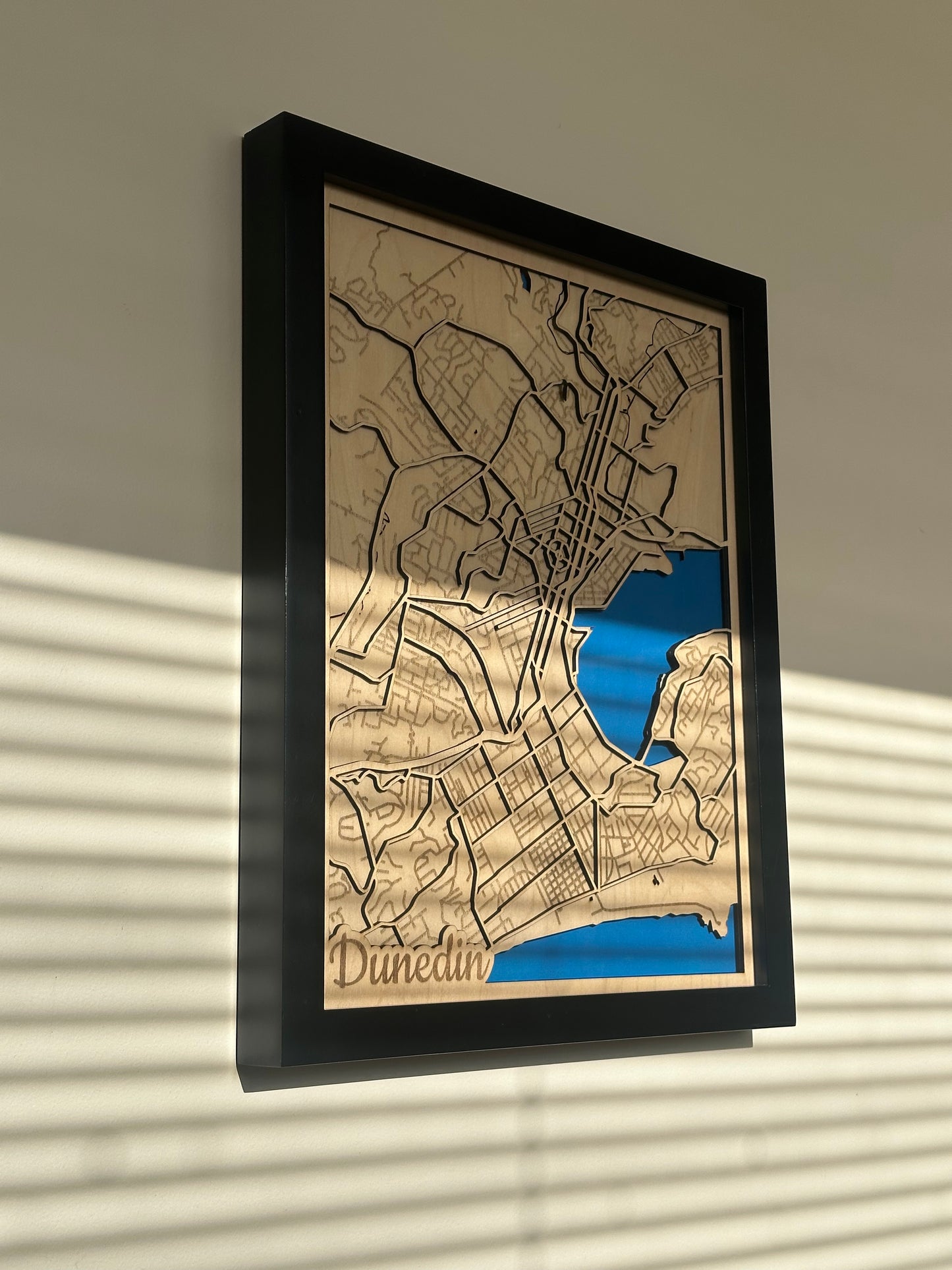 framed wooden map of Dunedin on a wall